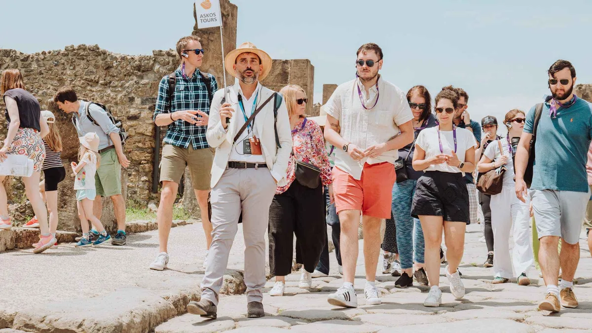 Archaeologist guide explaining a fresco to a small group at Pompeii on a Pompeii entry ticket and guided tour, Italy