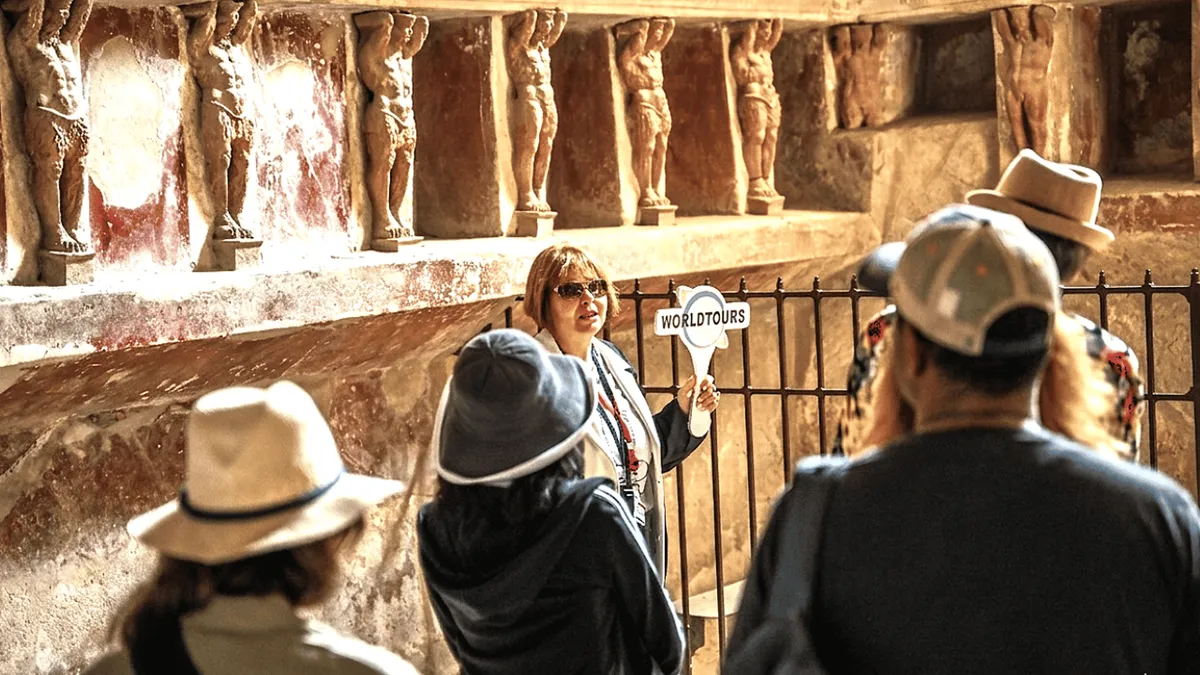 Small group listening to an archaeologist among the columns of the Pompeii Forum on a Pompeii and Herculaneum day trip from Naples, Italy